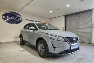 Nissan Qashqai gris en 3/4 avant droit, avec calandre noire et plaque "OCCASION" visible en showroom.