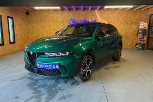 Vue 3/4 avant d'une Alfa Romeo Tonale 1.5 MHEV 130 TCT7 vert foncé avec jantes distinctives en intérieur showroom.