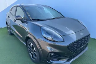 Vue 3/4 avant droit d'un Ford Puma gris magnetic avec calandre noire et jantes alliage 17 pouces.