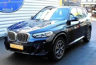 BMW X3 xDrive 30e bleu métal vu en 3/4 avant droit, avec calandre imposante et jantes M Sport distinctives.