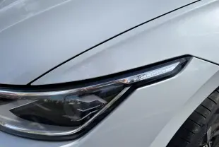 Gros plan sur le phare avant droit blanc de la Volkswagen Golf 1.5 eTSI Edition 50 2024 avec détails LED distinctifs.