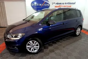 Volkswagen Touran bleu 3/4 avant droit, avec jantes alliage et rétroviseurs noirs brillants en intérieur showroom