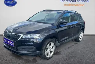 SKODA KAROQ noir vue 3/4 avant droit avec jantes alu et barres de toit sur fond clair.