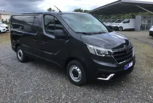 Renault Trafic Fourgon gris comète vu en 3/4 avant droit, avec calandre noire et phares LED distinctifs.