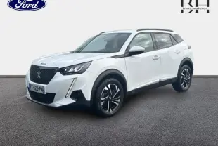 Peugeot 2008 blanc banquise vue 3/4 avant droit avec jantes alu et barres de toit noires.