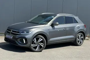Volkswagen T-Roc gris Indium en 3/4 avant droit, avec jantes alliage 18" Nevada et logo R-Line sur calandre.