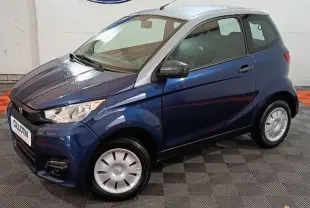 Vue 3/4 avant droit d'une AIXAM CITY PACK 482D 2024 bleu avec toit blanc et enjoliveurs de roues argentés.