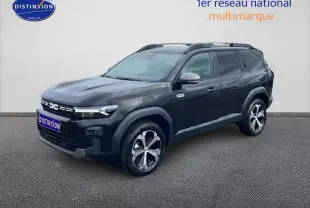SUV Dacia Bigster noir en 3/4 avant droit, avec jantes alliage diamantées et barres de toit visibles.
