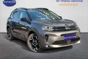 Citroën C5 Aircross gris Platinium en 3/4 avant droit avec jantes alliage et barres de toit visibles.