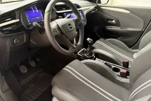 Vue intérieure côté conducteur de l’Opel Corsa 2025, volant multifonctions cuir synthétique et sièges tissu gris à bandes claires.