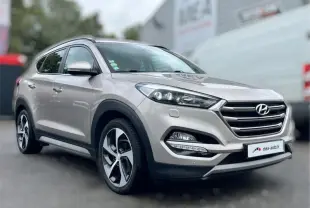 Vue 3/4 avant droite d'un Hyundai Tucson 2017 blanc sable avec calandre chromée et jantes alliage bicolores.