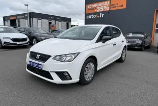 SEAT Ibiza blanc candy vue 3/4 avant droit, avec jantes enjoliveurs et rétroviseurs noirs sur parking.
