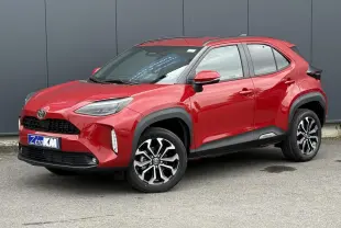 Toyota Yaris Cross rouge intense en 3/4 avant droit, avec jantes alliage et protections noires sur les passages de roue.