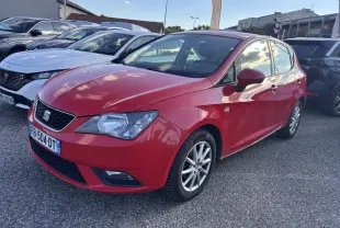 SEAT Ibiza 1.2 TSI rouge clair vue 3/4 avant droit sur parking avec jantes alliage et calandre noire.