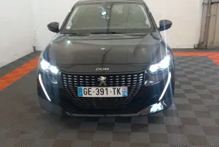 Peugeot 208 noire vue de face, phares LED allumés et signature lumineuse en forme de griffes visibles.