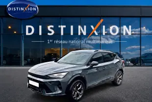 Vue 3/4 avant droite d'un CUPRA Formentor 1.5 etsi hybrid bleu fjord avec jantes 18 pouces devant un showroom Distinxion.