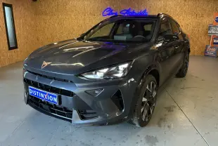 Vue 3/4 avant droite d'un CUPRA Formentor gris foncé 2024 avec phares LED et jantes bi-ton dans un showroom.