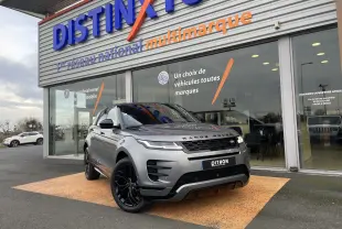 Vue 3/4 avant d'un Range Rover Evoque 200D SE R-Dynamic gris Eiger avec jantes noires, devant un showroom multimarque.