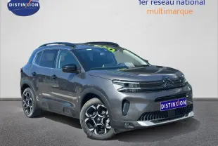 Citroën C5 Aircross gris Platinium vue 3/4 avant droit avec jantes alu et barres de toit visibles.