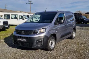 Peugeot Partner gris Artense vu en 3/4 avant droit, fourgonnette utilitaire avec calandre noire et jantes acier.
