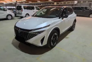 Nissan Qashqai blanc nacré avec toit noir, vu en 3/4 avant droit dans un parking intérieur.