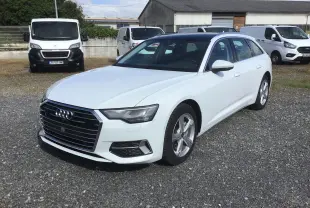 Audi A6 Avant blanc glacier vue 3/4 avant droit sur parking avec toit noir contrasté et jantes alliage.