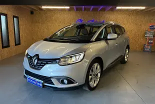 Renault Grand Scenic gris vue 3/4 avant droit dans un garage avec éclairage intérieur et plaques Distinxion.