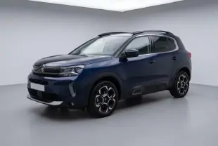 Citroën C5 Aircross hybride bleu foncé vu en 3/4 avant droit, avec jantes distinctives et barres de toit noires.