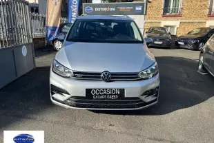 Vue de face d'un Volkswagen Touran R-Line gris reflet d'argent, avec calandre et phares LED visibles en plein jour.
