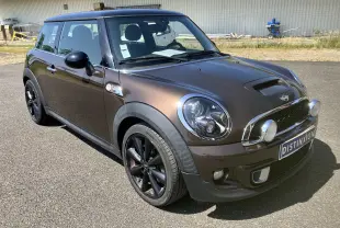 MINI Cooper S R56 marron vue 3/4 avant droit avec phares additionnels et jantes noires sur parking.
