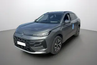 Volkswagen T-Roc gris loup en 3/4 avant droit, avec calandre noire et jantes alu bicolores visibles.