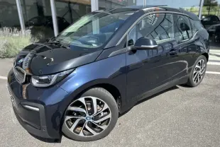 BMW i3 électrique bleue vue en 3/4 avant droit, mettant en valeur ses jantes distinctives et son design compact.