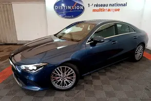 Vue 3/4 avant droite d'une Mercedes Classe CLA bleu métallisé avec jantes alliage multibranches dans un showroom.