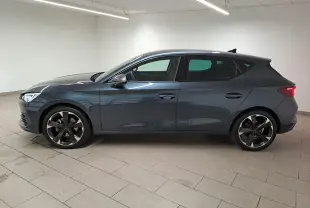 Profil droit d'une CUPRA Leon 1.5 TSI 150 DS7 V gris magnétique 2023, avec jantes noires et design sportif.