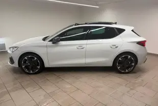 Vue de profil côté gauche d'une CUPRA Leon blanche Nevada avec toit ouvrant panoramique et jantes noires.