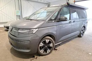 Vue 3/4 avant droit du Volkswagen California T7 2.0 TDI 150 DSG Ocean gris Indium avec jantes alliage noires brillantes.