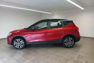 Vue de profil côté gauche d'un SEAT Arona 2025 rouge Désir avec toit noir Minuit et jantes alliage.