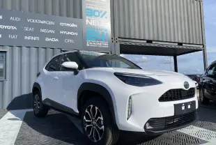 Toyota Yaris Cross blanc pur vue 3/4 avant droit avec jantes alliage et rétroviseurs blancs sur fond urbain.