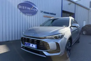 Vue 3/4 avant droite du SUV MG ZS gris Hampstead avec calandre imposante et phares LED distinctifs.