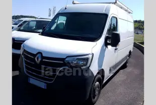 Renault Master blanc en 3/4 avant droit avec galerie de toit et pare-chocs noir visible sur parking extérieur.