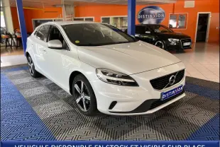 Volvo V40 blanc en 3/4 avant droit dans un showroom avec jantes alliage et plaque Distinxion visible.