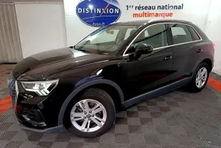 Audi Q3 noir vue 3/4 avant droit dans un showroom avec jantes argentées et phares allumés.