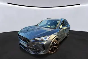 Vue 3/4 avant d’un CUPRA Formentor gris foncé avec jantes noires et calandre distinctive, sur fond neutre.