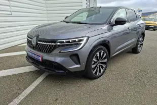 Renault Austral E-Tech gris schiste en 3/4 avant droit, avec calandre distinctive et jantes bi-ton modernes.