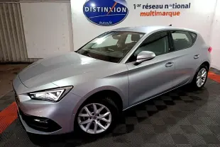 SEAT LEON gris clair vue 3/4 avant droit en intérieur avec jantes alliage et phares LED allumés