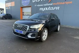 Audi Q2 noir brillant vue 3/4 avant droit avec calandre chromée et jantes argentées sur parking extérieur.