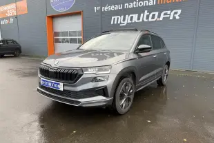 SKODA KAROQ 1.5 TSI Sportline gris graphite métallisé en 3/4 avant avec jantes alliage et toit panoramique.