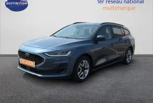 Ford Focus SW bleu foncé vue 3/4 avant droit avec barres de toit et jantes classiques 16 pouces.