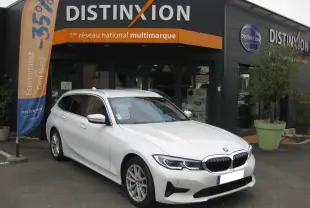 BMW Série 3 Touring G21 320DA xDrive blanc vue 3/4 avant droit devant un concessionnaire Distinxion.
