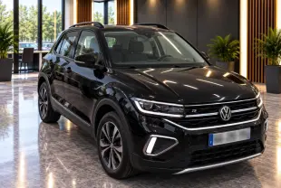 Volkswagen T-Cross 2025 noir métal en vue 3/4 avant, finition R-Line avec signature lumineuse distinctive et jantes alliage.